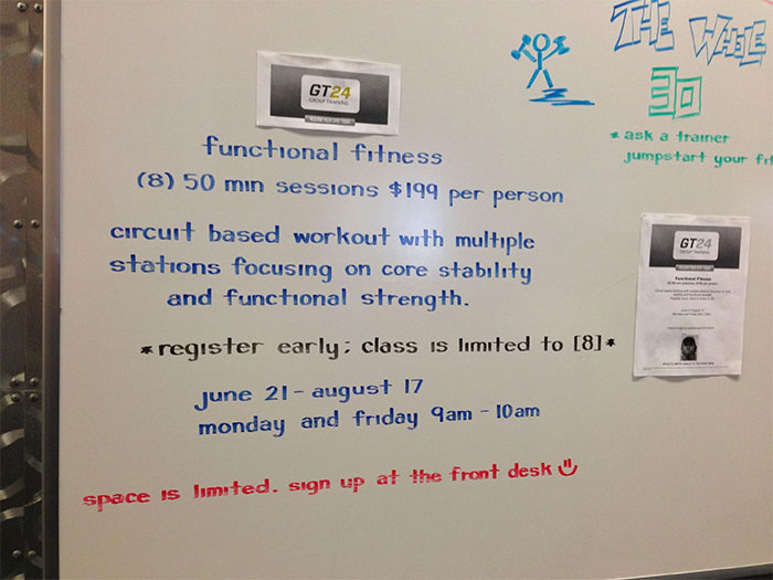 Whiteboard displaying beautiful handwriting showcasing a functional fitness schedule and pricing details.