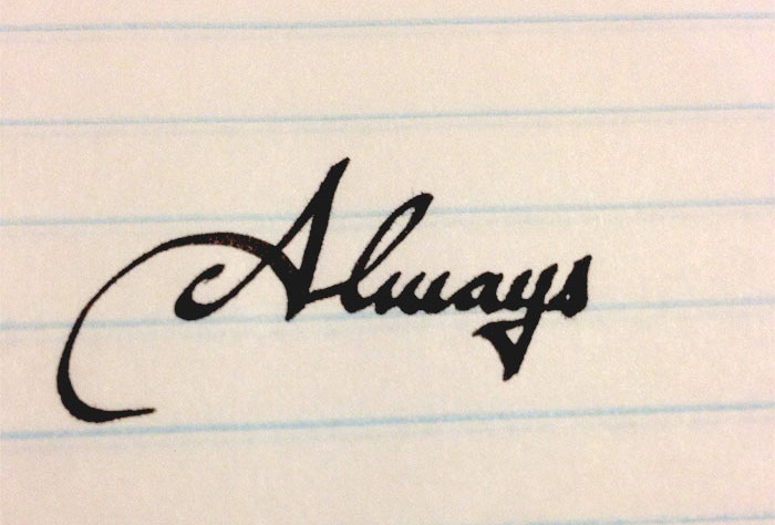Beautiful handwriting example spelling "Always" in elegant cursive on lined paper.
