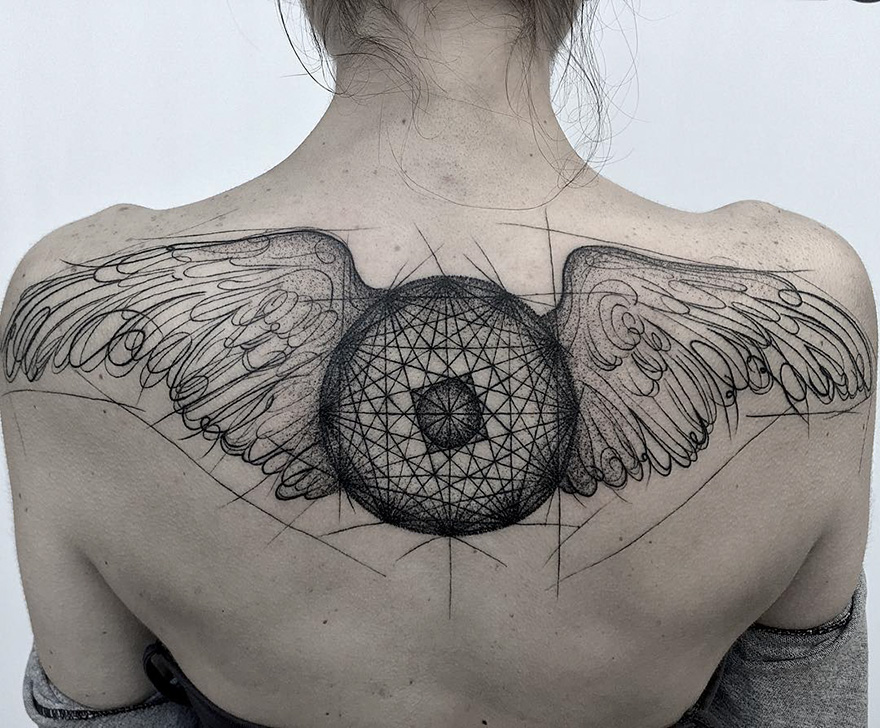 Sketch tattoo with wings and geometric design on a person's back, highlighting the beauty of imperfection.