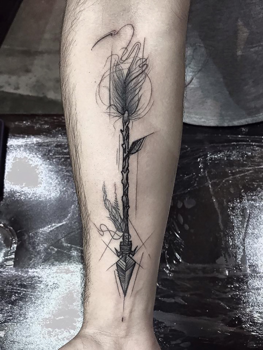 Sketch tattoo of an intricately designed arrow on forearm, showcasing the beauty of imperfection.