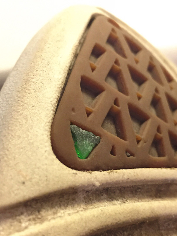 Close-up of a perfect fit between a triangular shoe tread and a piece of green glass, satisfying for perfectionists.