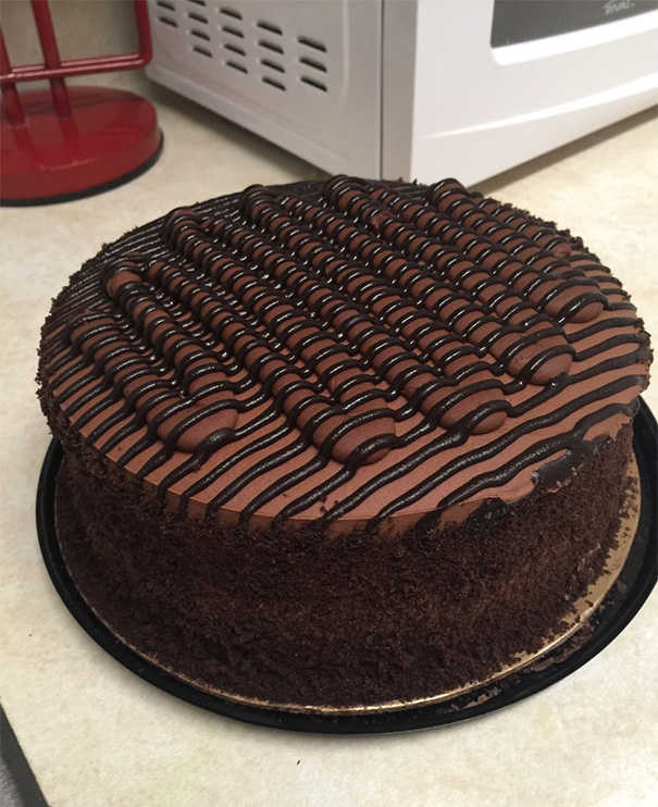Perfectly iced chocolate cake with a flawless zigzag pattern, satisfying any perfectionist's soul.