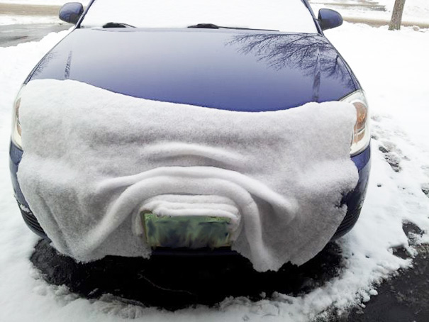 Snow-covered car front creating perfect symmetry for perfectionists' satisfaction.
