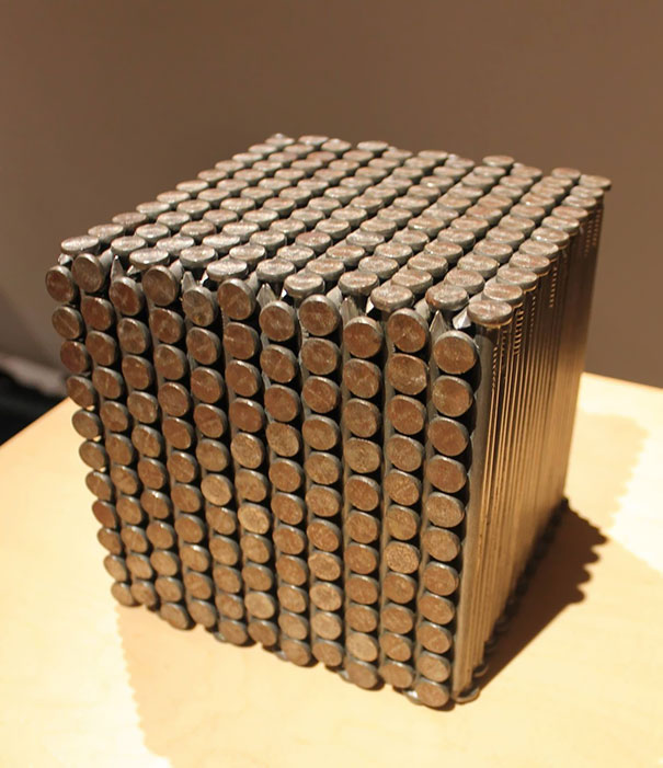 A perfectly stacked cube of nails, satisfying every perfectionist's soul with its geometric precision.