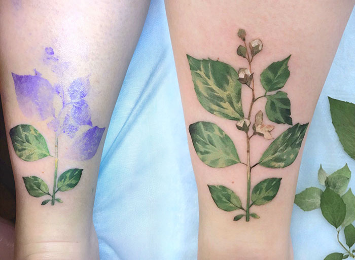 Botanical tattoos on skin using real leaves as stencils, showcasing detailed green foliage designs.