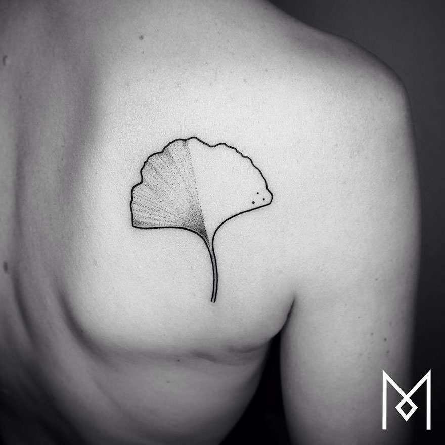 Minimalist single line tattoo of a ginkgo leaf on a person's back by Iranian-German artist.