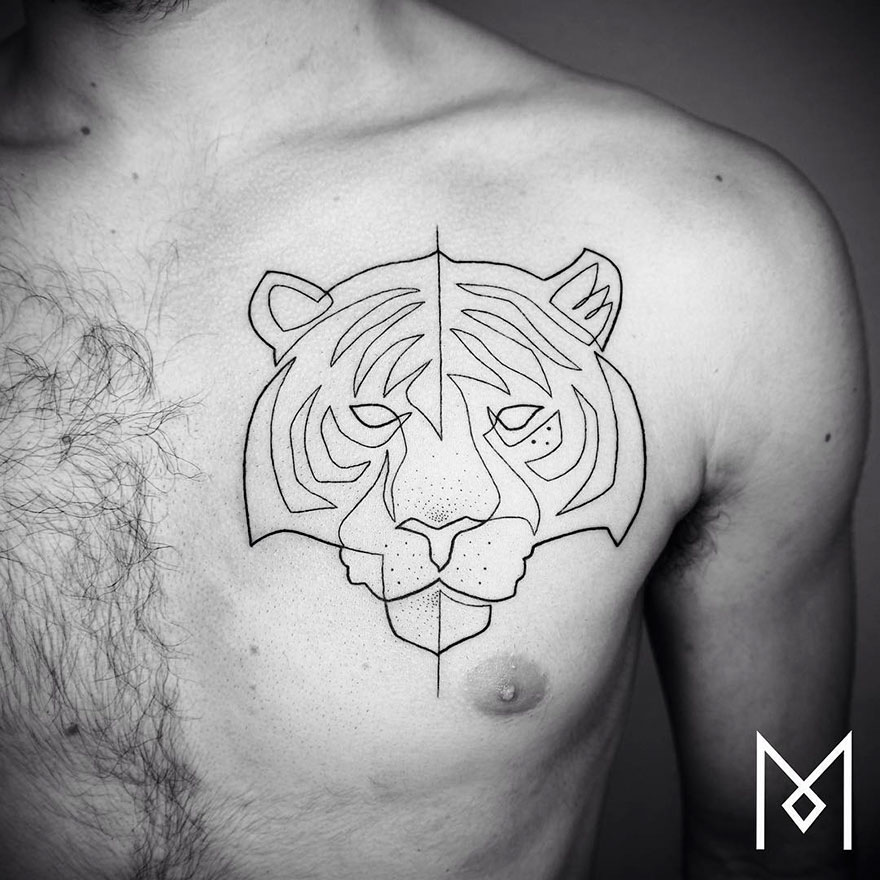 Minimalist single line tattoo of a tiger's face on a person's chest, featuring clean geometric design.