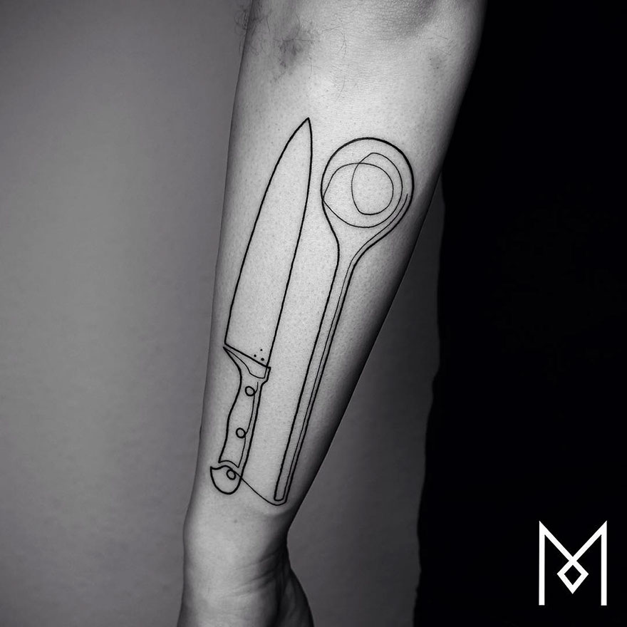 Minimalist single line tattoo of a knife and spoon on an arm.