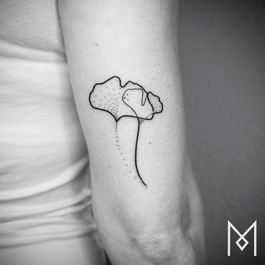 Minimalist single line tattoo on an arm, depicting abstract floral design by Iranian-German artist.