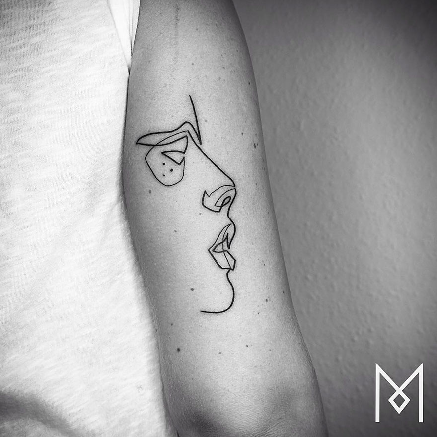Minimalist single line tattoo of a face on an arm, created by an Iranian-German artist.