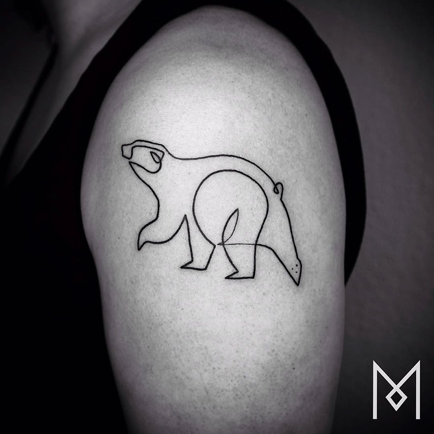 Minimalist single line tattoo of a bear on upper arm by Iranian-German artist.