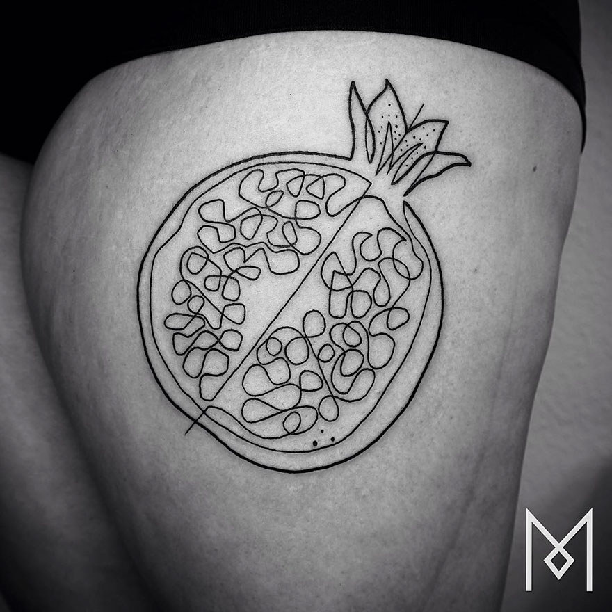 Minimalist single line tattoo of a pomegranate on skin by Iranian-German artist.