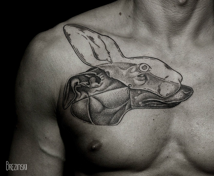 Surreal tattoo by Belarussian artist Ilya Brezinski, featuring a rabbit design on a person's chest.