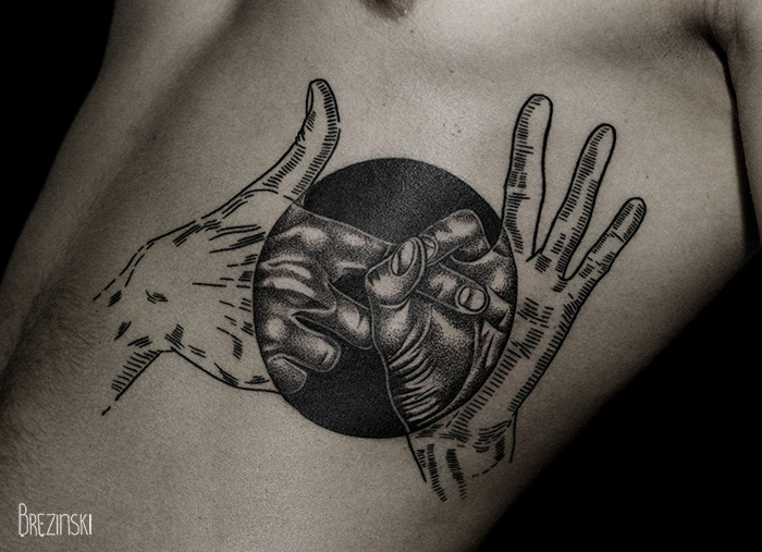 Surreal tattoo by Belarussian artist, featuring hands and a circle, inked on a person's side.