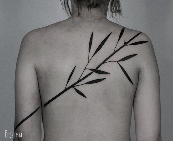 Surreal tattoo of a stylized branch on a person's back by Belarussian artist.