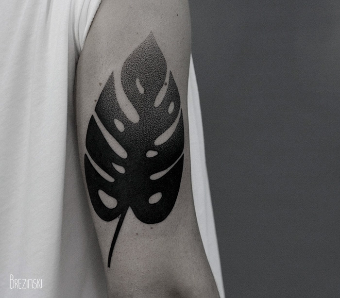 A surreal tattoo of a Monstera leaf on an arm, created by a Belarussian artist, showcasing fine dot work.