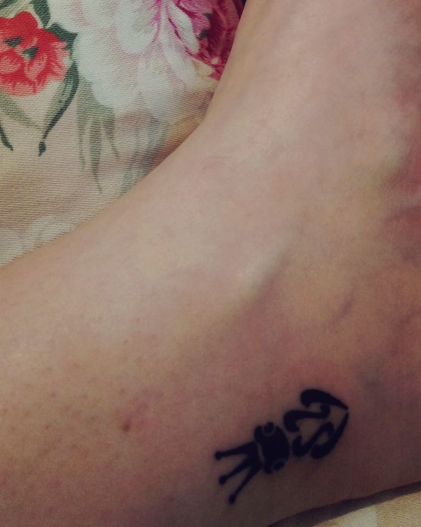 Small foot tattoo of a black ant on skin, highlighting minimalist design.