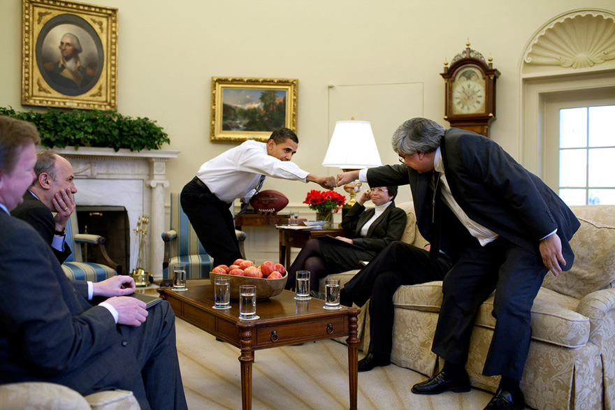 President Barack Obama Holding A Football, Offers A Fist-Bump, To Senior Staff Member Pete Rouse
