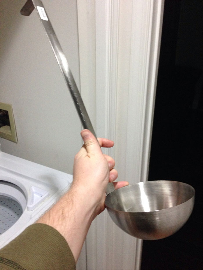 Huge ladle held by a person, symbolizing regret over online purchases.