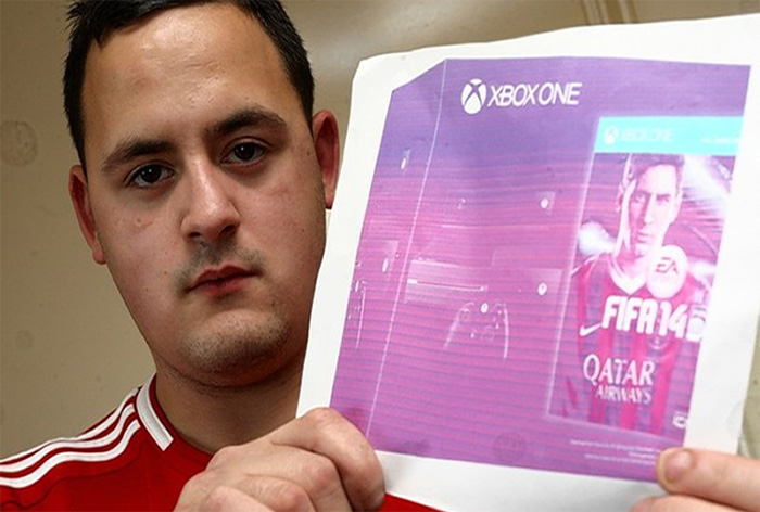 Person showing a printed image of an Xbox One FIFA game box, expressing regret over online purchase.
