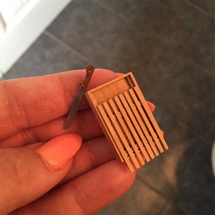 Tiny wooden bed held in hand, symbolizing regretted online purchases.