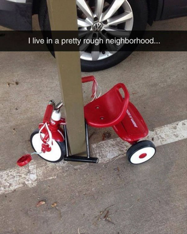 Hilarious Snapchat of a red tricycle locked to a pole in a rough neighborhood.