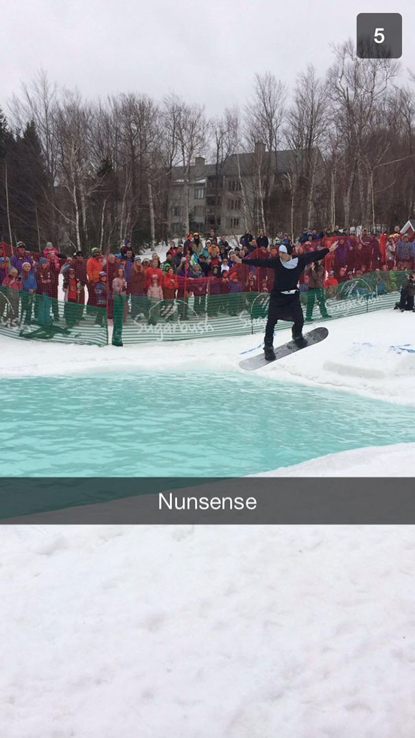 Snowboarder in a nun costume jumping over water, providing hilarious Snapchat moment.