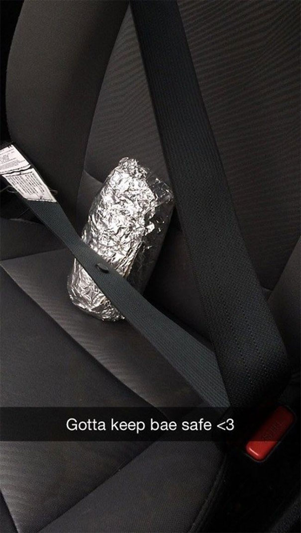 Funny Snapchat of a foil-wrapped burrito seat-belted in a car.