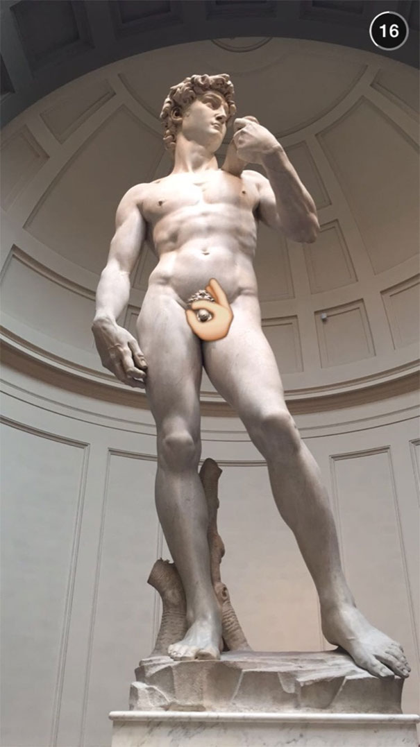 Statue of David with a funny Snapchat emoji covering part of it, creating a humorous effect.