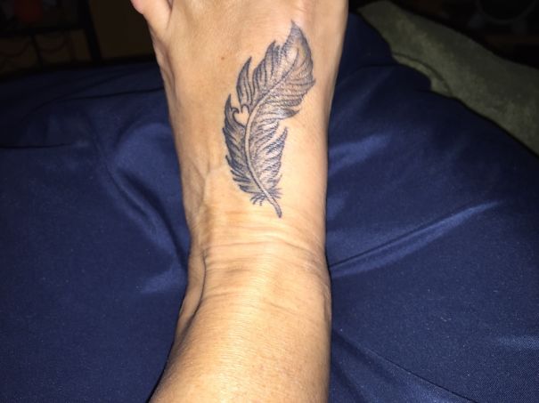 Feather tattoo on a foot showcasing minimalist design, emphasizing that less is more in small foot tattoo ideas.