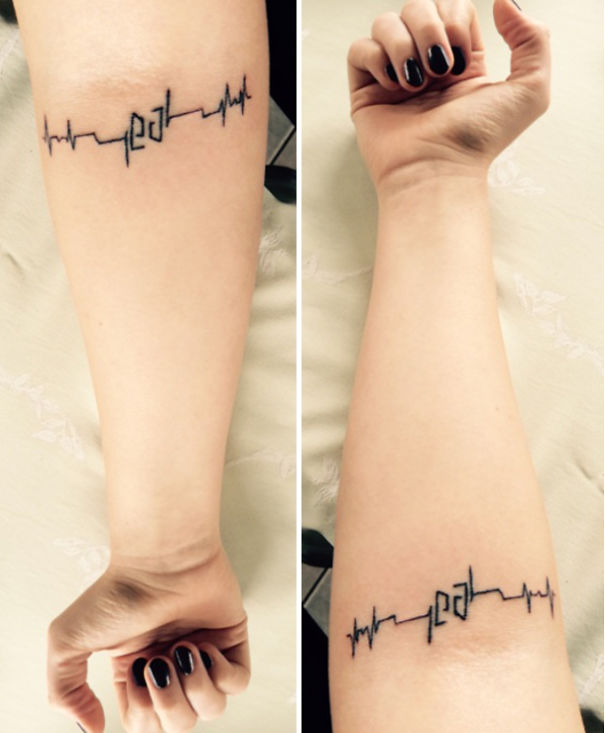 Tattoo in the form of an ECG line with hidden initials on a person's forearm, showcasing clever hidden meaning.