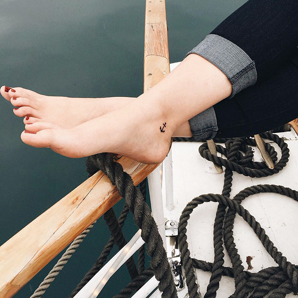 Small anchor foot tattoo on a boat, demonstrating less is more in minimalist tattoo design.