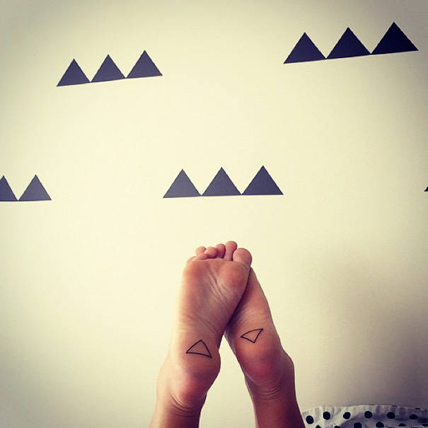 Minimalist small foot tattoos with geometric designs.