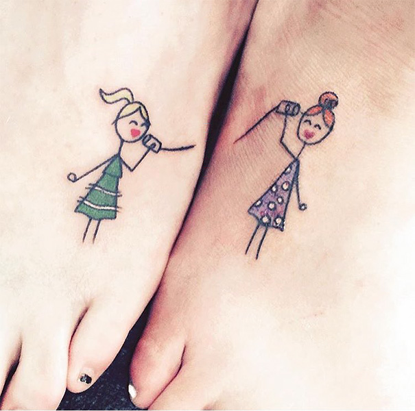 Small foot tattoos of two stick-figure girls talking, showcasing minimalist design.