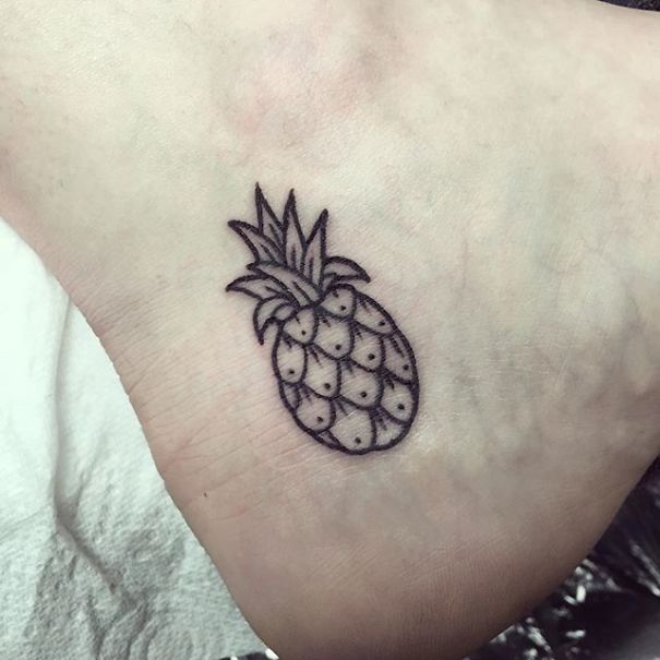 Minimalist pineapple design as a small foot tattoo, illustrating "less is more" in tattoo art.