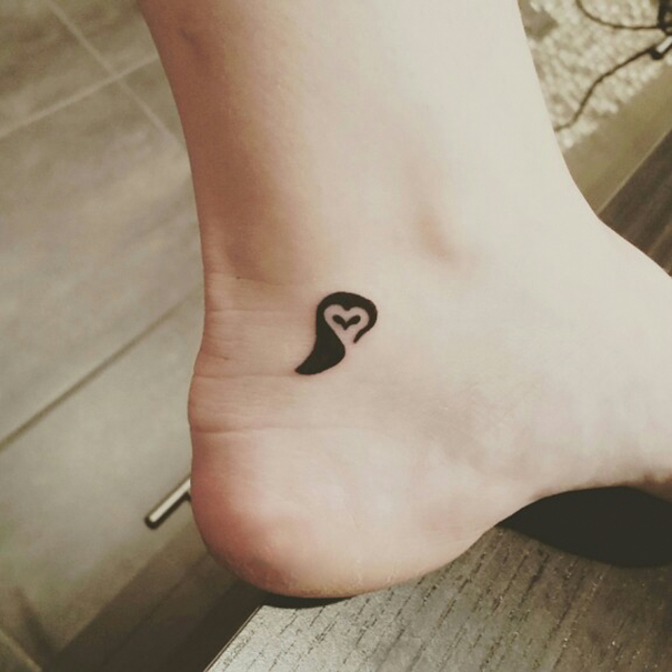 Minimalist small foot tattoo with heart design, emphasizing the concept that less is more in tattoo choices.