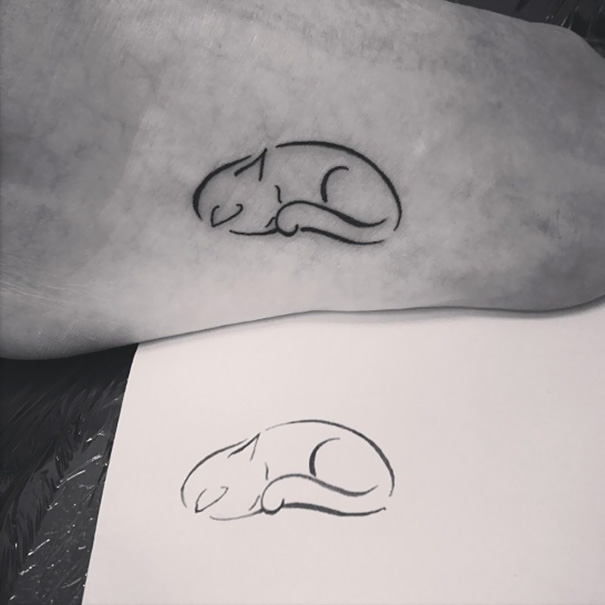 Minimalist foot tattoo of a sleeping cat, showcasing a simple and elegant design.