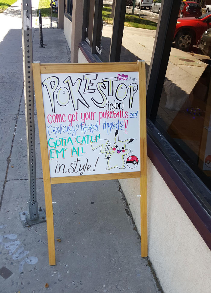 Sign advertising Pokéstop inside a store, inviting visitors to get Pokéballs and themed items, leveraging the Pokémon Go craze.