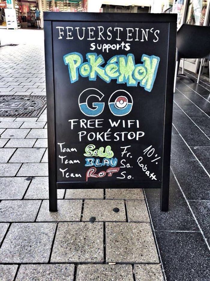 Chalkboard sign offering free WiFi and Pokéstop access, promoting Pokémon Go enthusiasm.