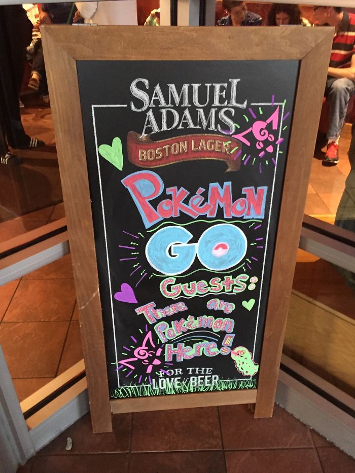Chalkboard sign at a bar welcoming Pokemon Go players with colorful drawings.