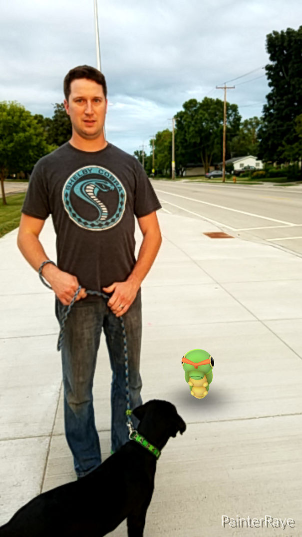 Man walking dog on sidewalk, both looking at a Pokémon from Pokémon Go on the ground.
