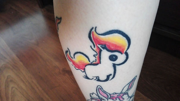 Pokemon tattoo featuring a stylized, colorful design on a person's leg.