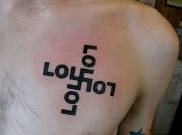 "Creative cover-up tattoo on a person's chest, featuring abstract black letters design."