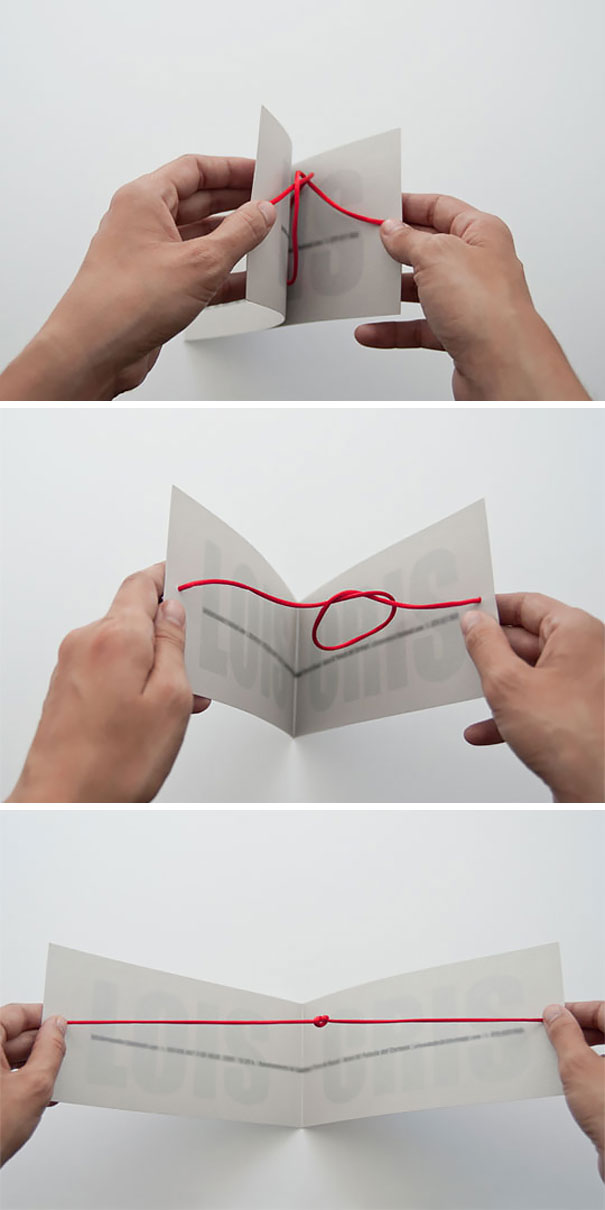 Hands holding creative wedding invitations made with red string threading through folded paper pages.