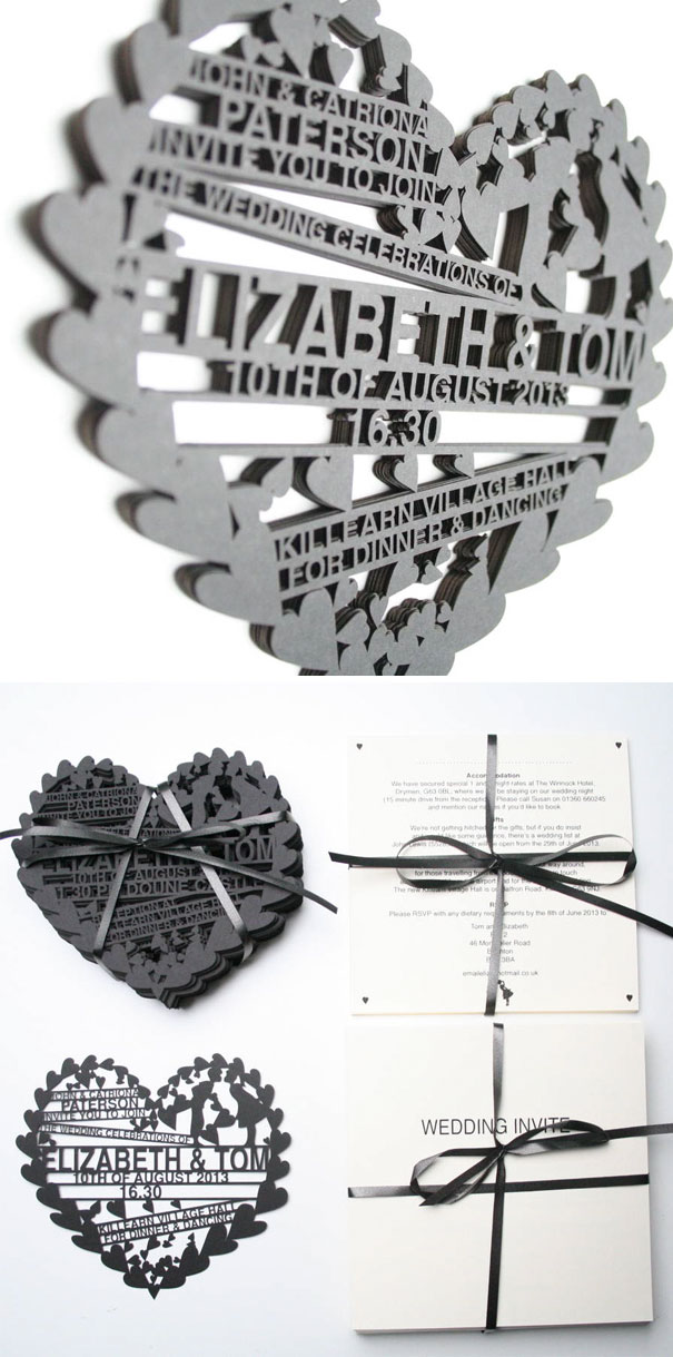 Intricate black heart-shaped laser cut wedding invitation with ribbon-tied white RSVP cards and details.