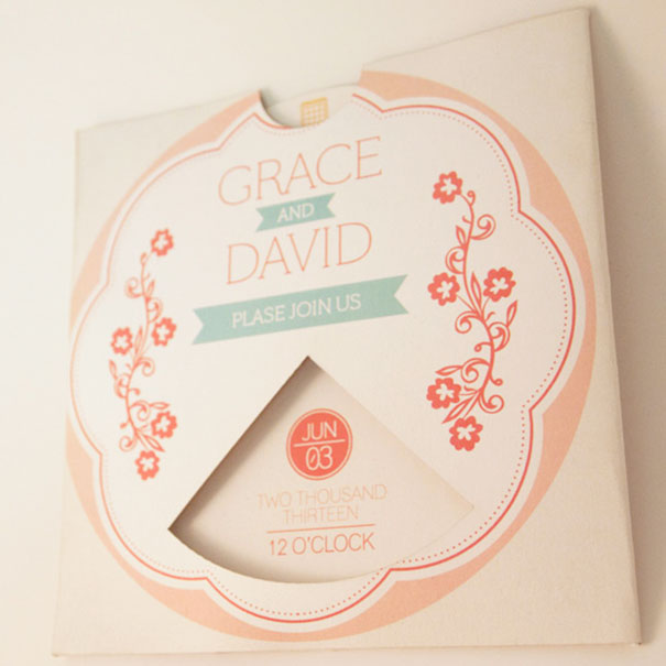 Wedding invitation card with floral design and soft pastel colors featuring names and event date detail.