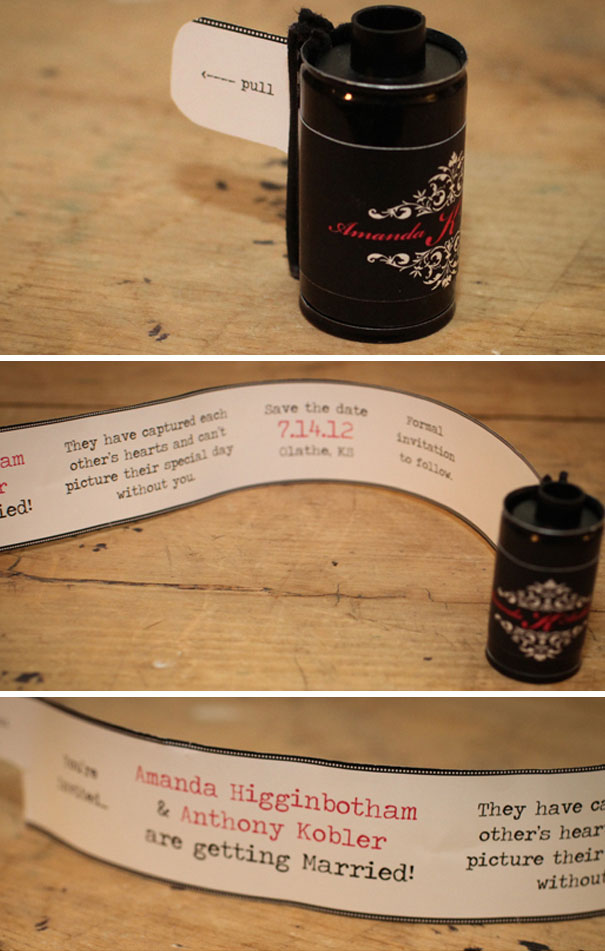 Creative wedding invitation styled like a film roll with personalized text and a pull-out announcement strip on wooden surface.