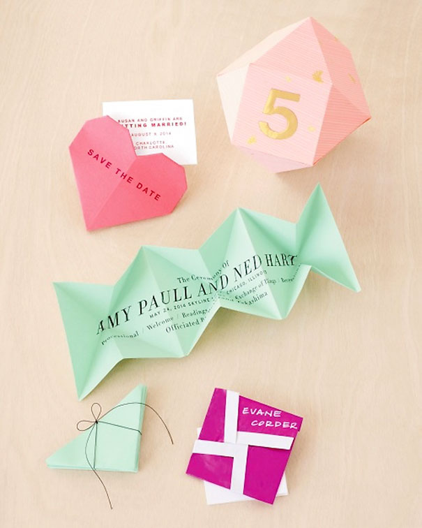 Creative wedding invitations including folded paper designs, origami shapes, and unique calligraphy on pastel paper.