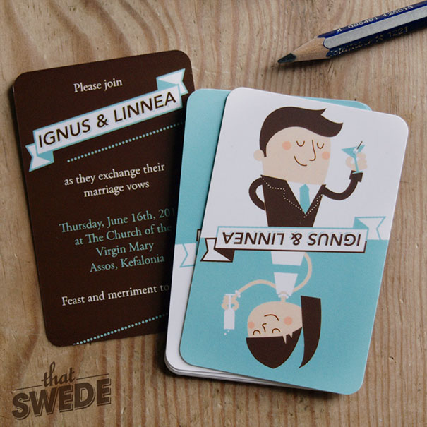 Wedding invitations with creative cartoon illustrations and modern design on a wooden surface with pencils nearby.
