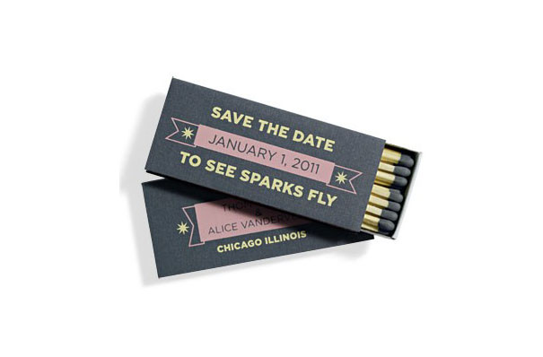 Creative wedding invitation designed as a matchbox with save the date text and black and gold matches inside.